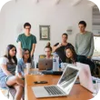 Group of people with laptops sitting around a table