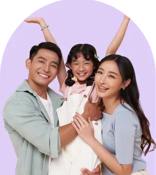 A happy family portrait featuring a man, woman, and a child smiling together outdoors.