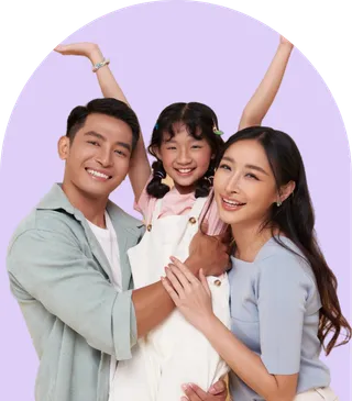 A happy family portrait featuring a man, woman, and a child smiling together outdoors.