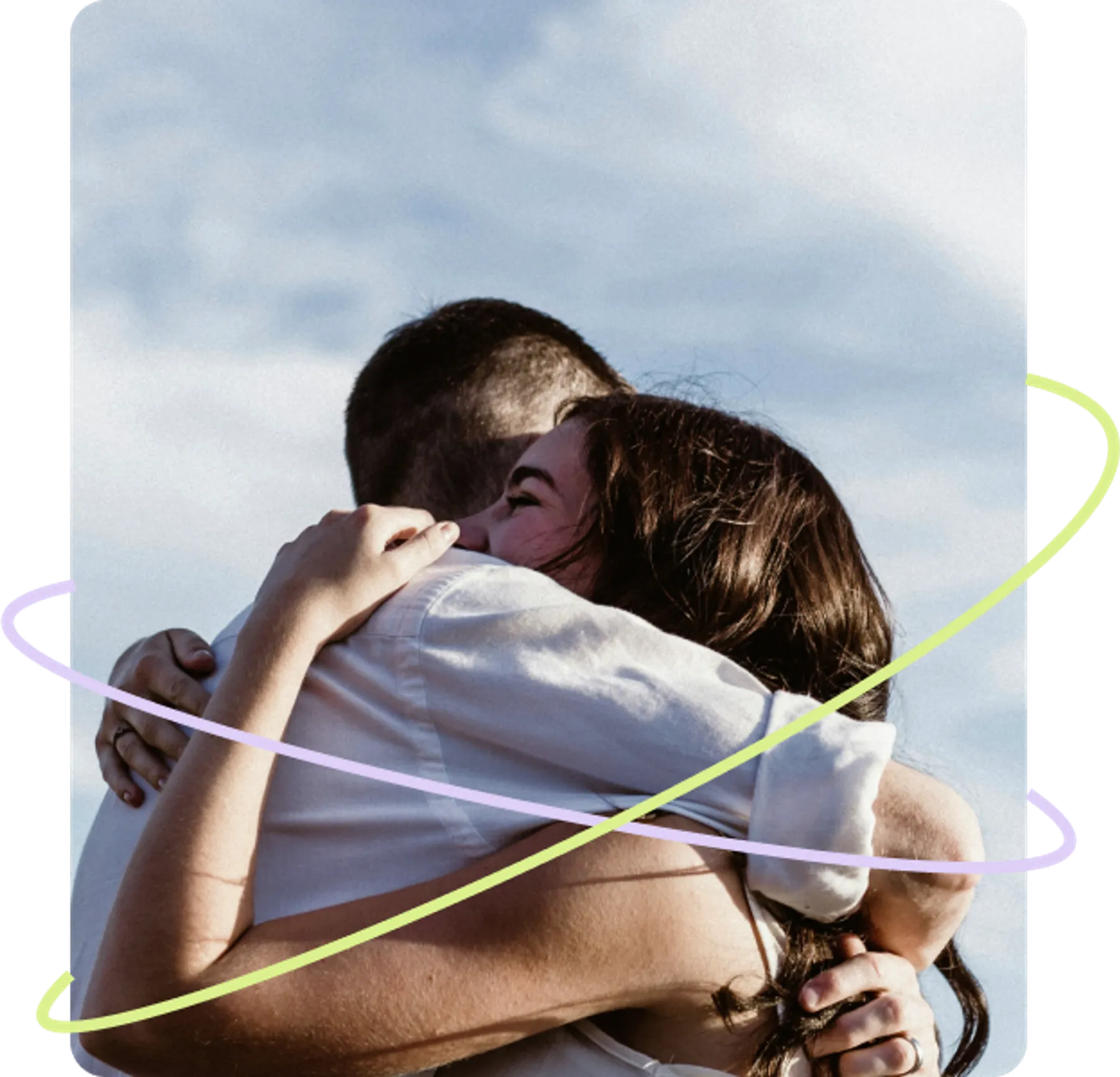 A woman with long dark hair hugs her partner tightly in an emotional reunion under a bright sky.
