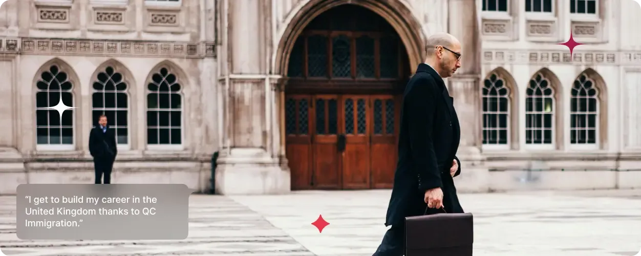 Man in business attire holding a briefcase walking outside a historic UK-style building.