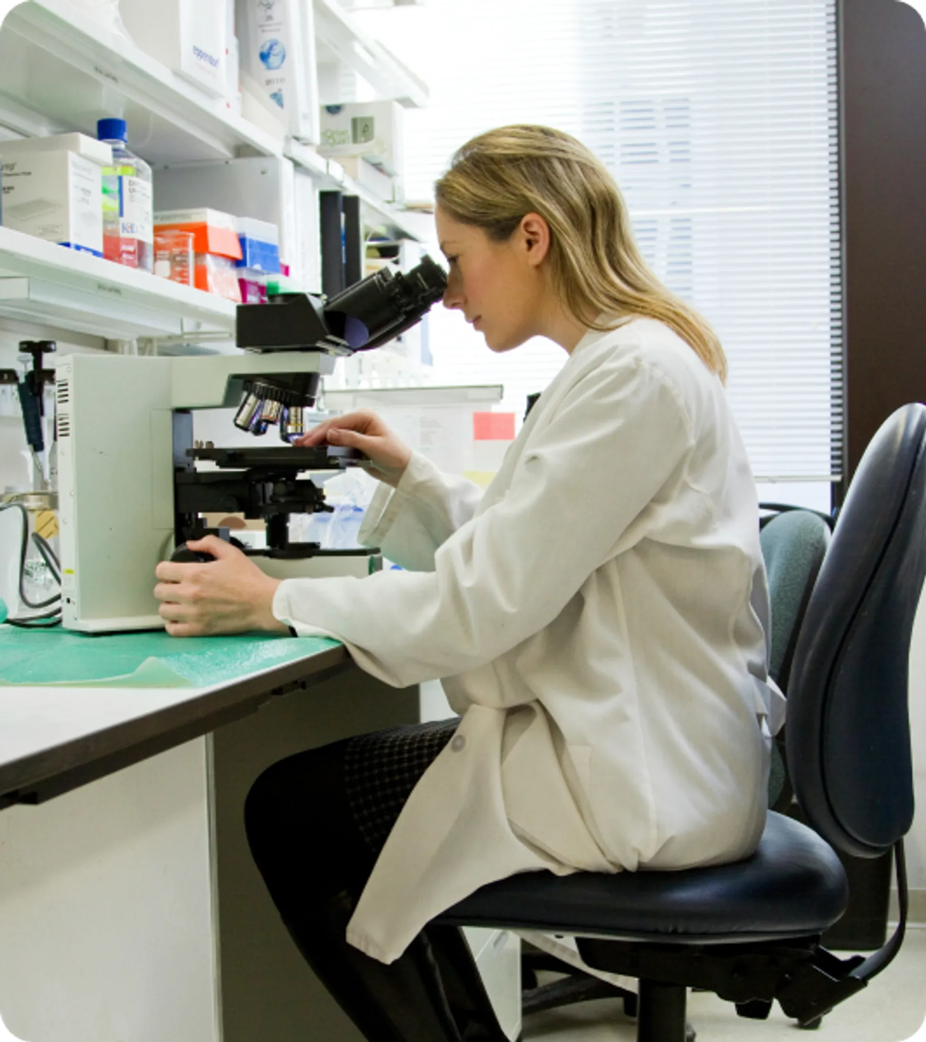 Female scientist working at a microscope in a lab, representing high-skilled professionals eligible for the UK Global Talent Visa