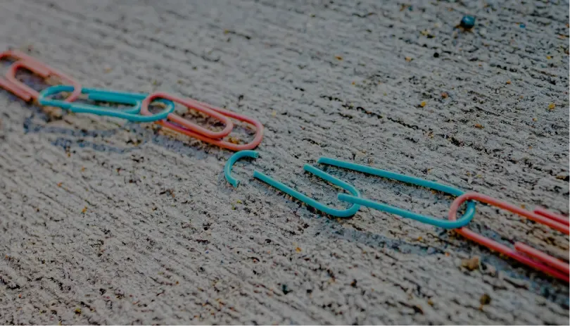 Colorful chain of paperclips on a concrete surface, symbolizing connection, support, or documentation links