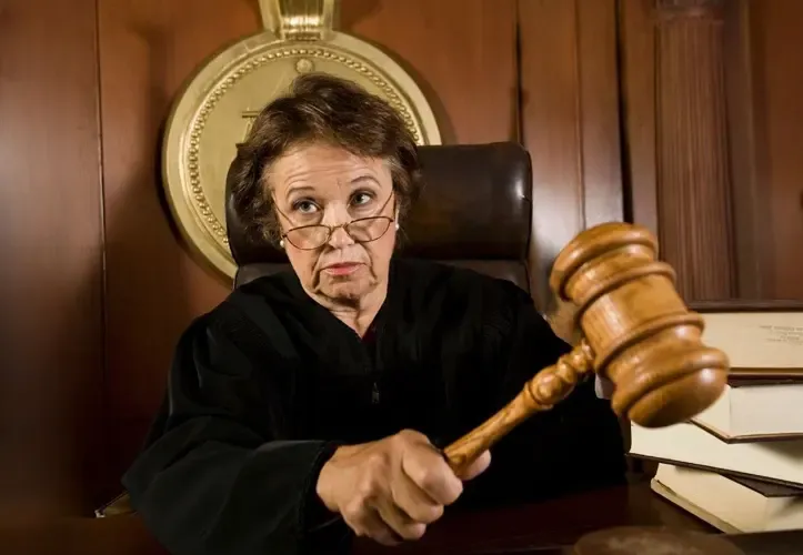 Female judge in a courtroom holding a gavel, symbolizing legal authority and decision-making in the justice system
