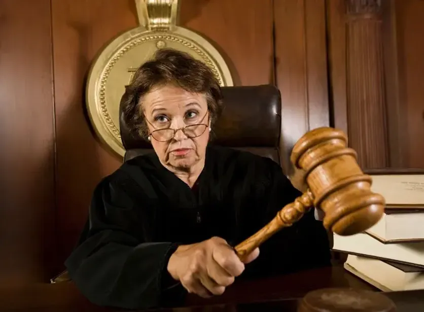 Female judge in a courtroom holding a gavel, symbolizing legal authority and decision-making in the justice system