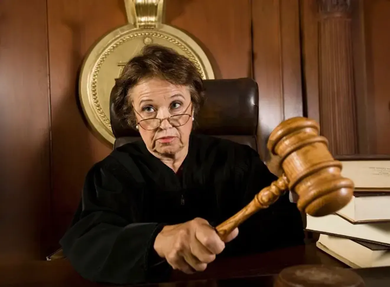 Female judge in a courtroom holding a gavel, symbolizing legal authority and decision-making in the justice system