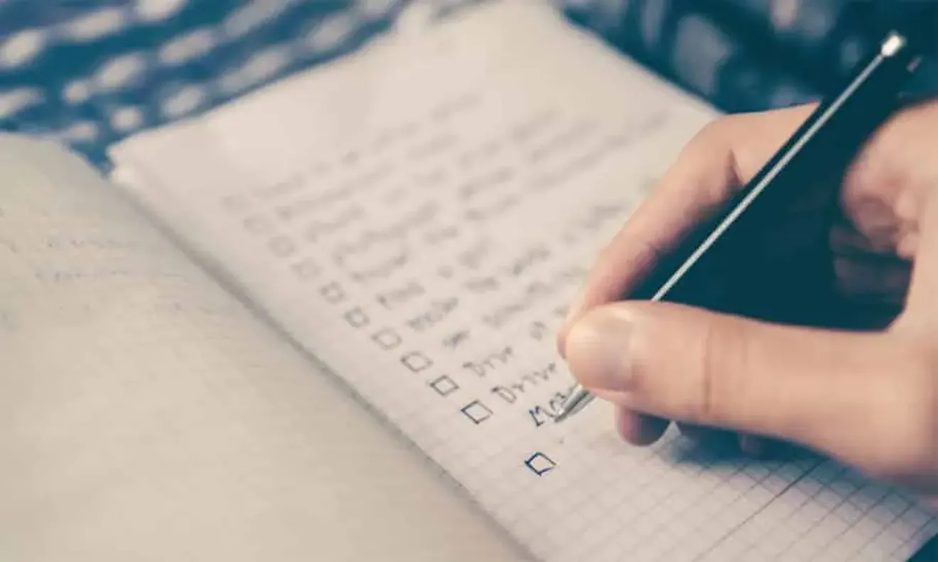 Close-up of hand writing in a notebook, symbolizing the importance of accuracy in immigration or visa application forms