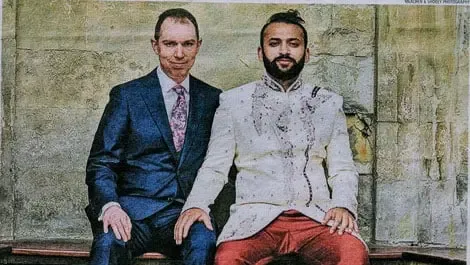 Portrait of a same-sex couple in formal attire, representing partnership-based immigration rights in the UK