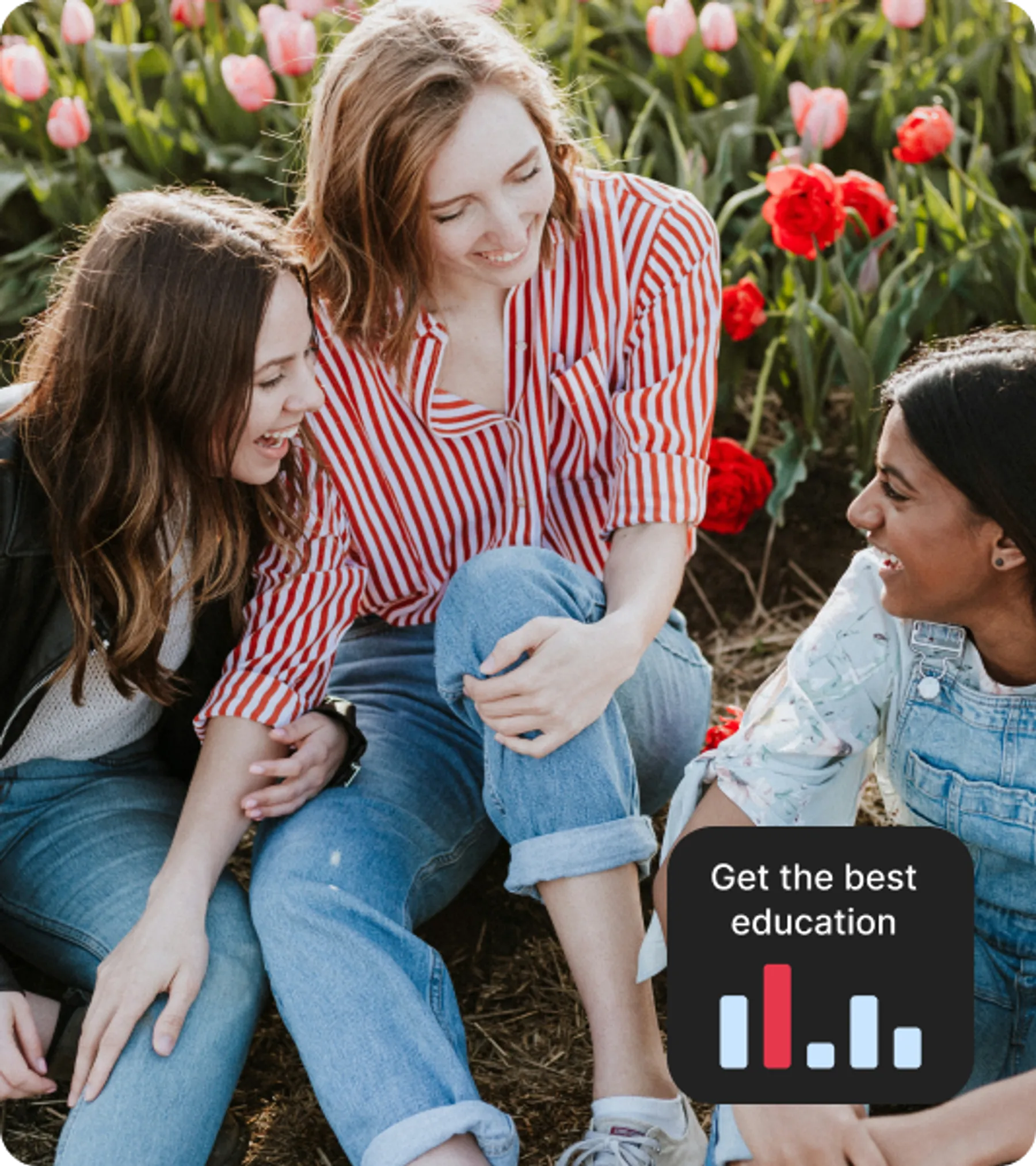 Three young women sitting and smiling together among blooming tulips.