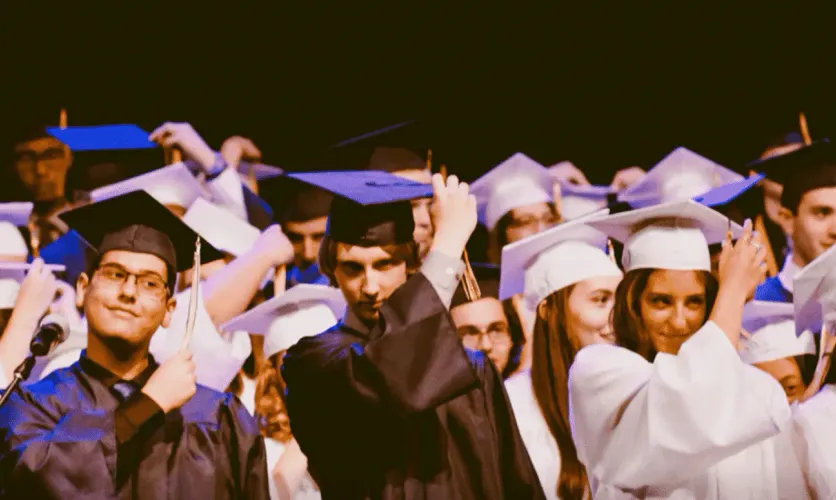 Students in caps and gowns celebrating at a graduation ceremony