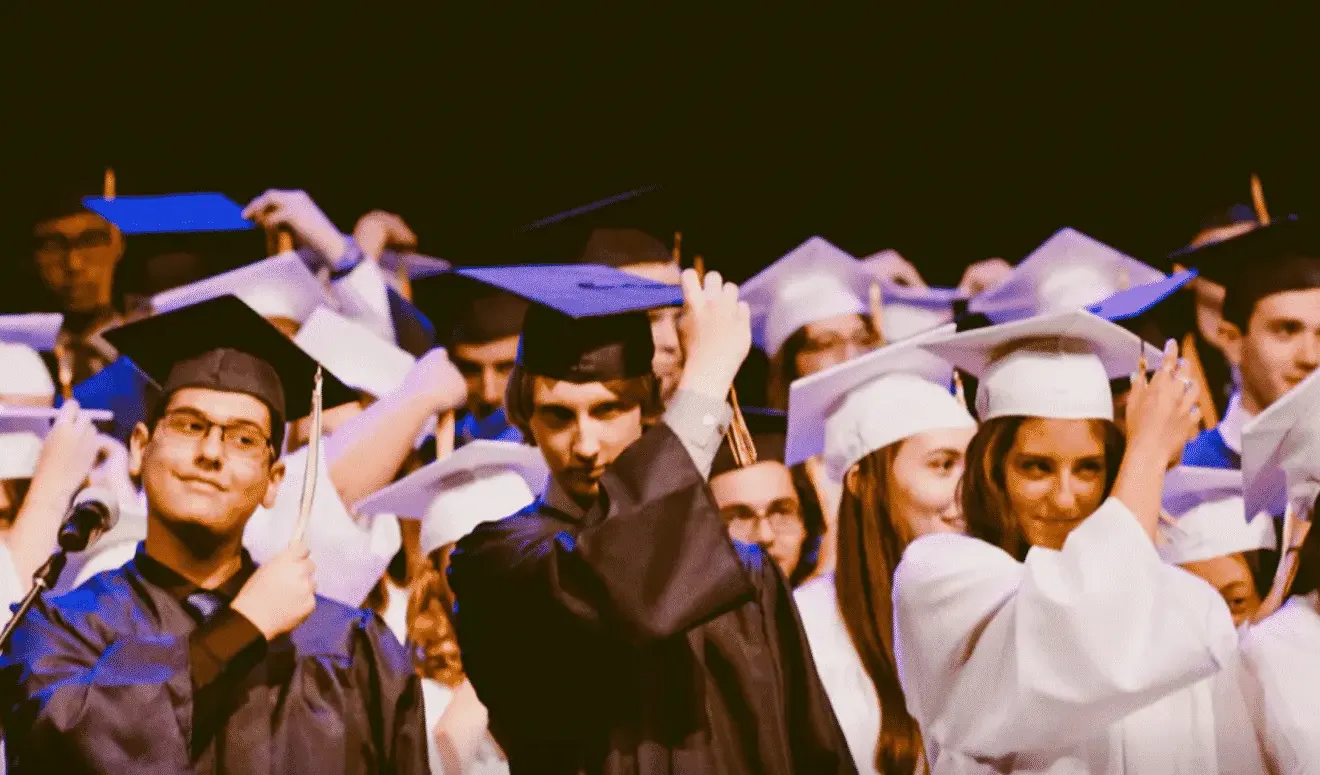 Students in caps and gowns celebrating at a graduation ceremony