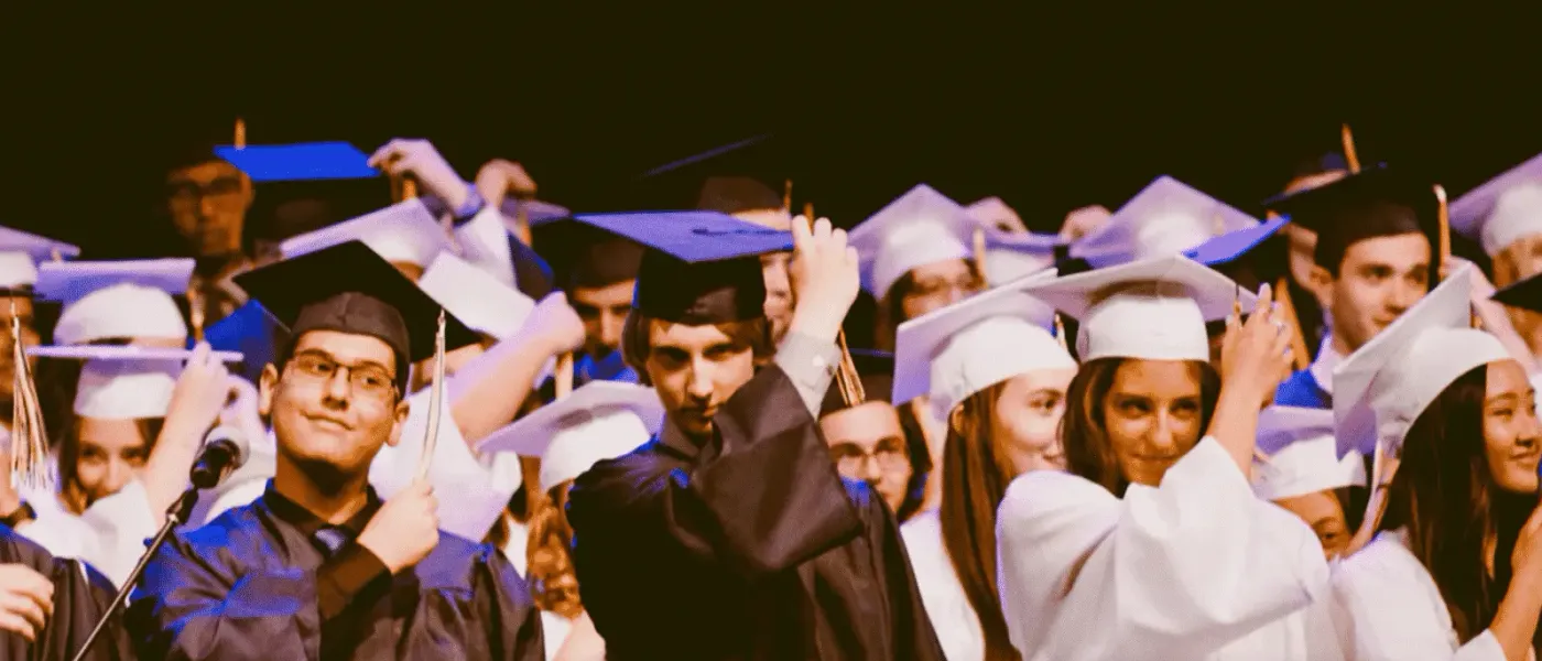 Students in caps and gowns celebrating at a graduation ceremony