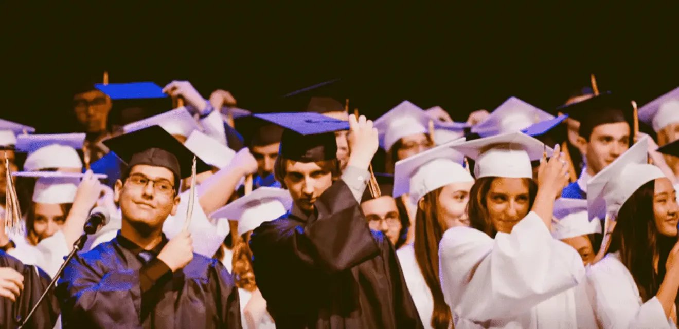 Students in caps and gowns celebrating at a graduation ceremony