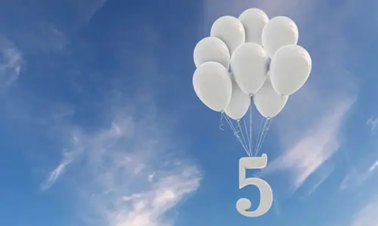 White balloons floating in the sky forming the number five, symbolizing Tier 5 temporary work or youth mobility visa