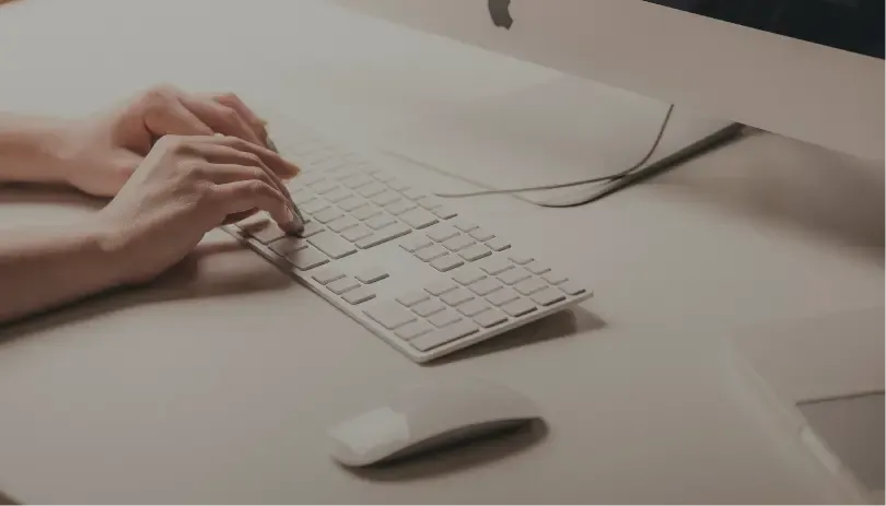 Hands typing on a white keyboard, representing digital document preparation or online application