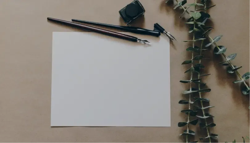 Blank white paper with pen and ink pot, symbolizing writing official UK immigration correspondence or appeals