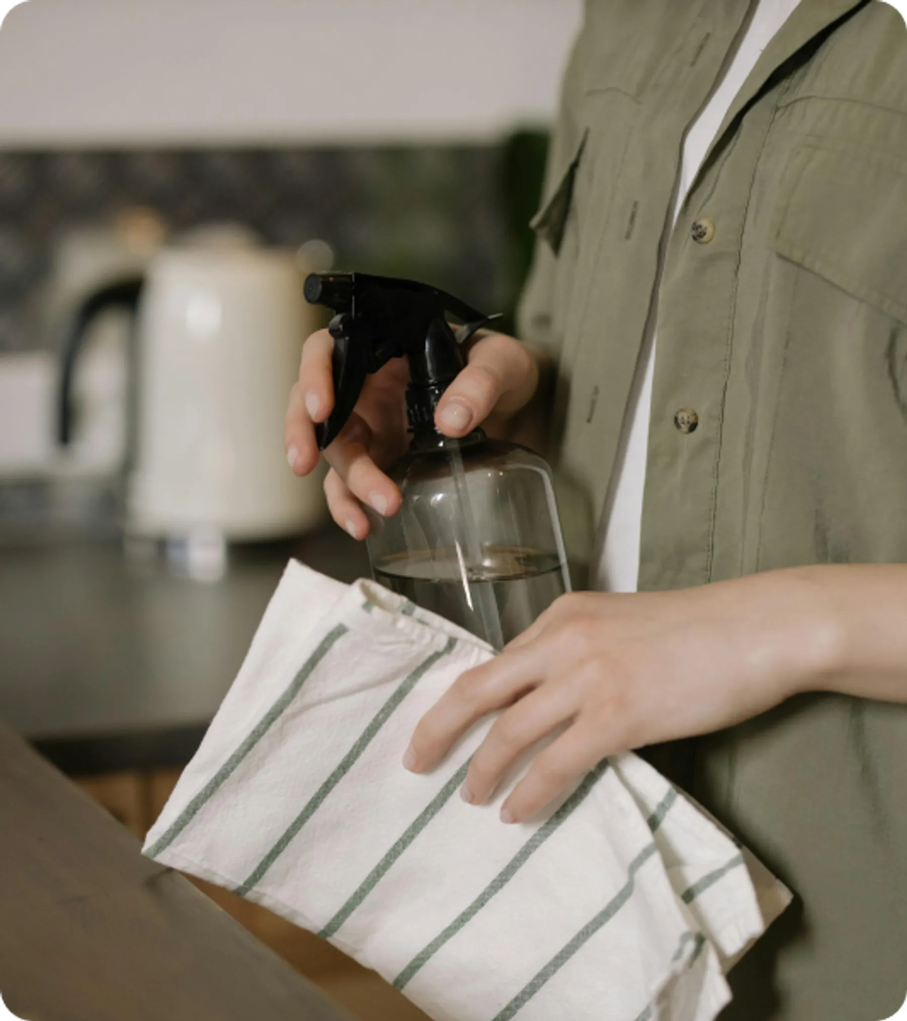Close-up of person cleaning with spray bottle and cloth, representing eligibility for the UK Overseas Domestic Worker Visa