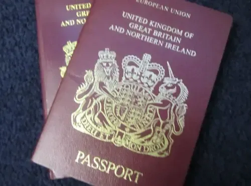 Close-up of two United Kingdom passports placed on a dark surface, symbolizing British citizenship and travel documentation