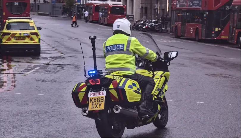 UK police officer on motorcycle conducting a traffic penalty stop on a city street