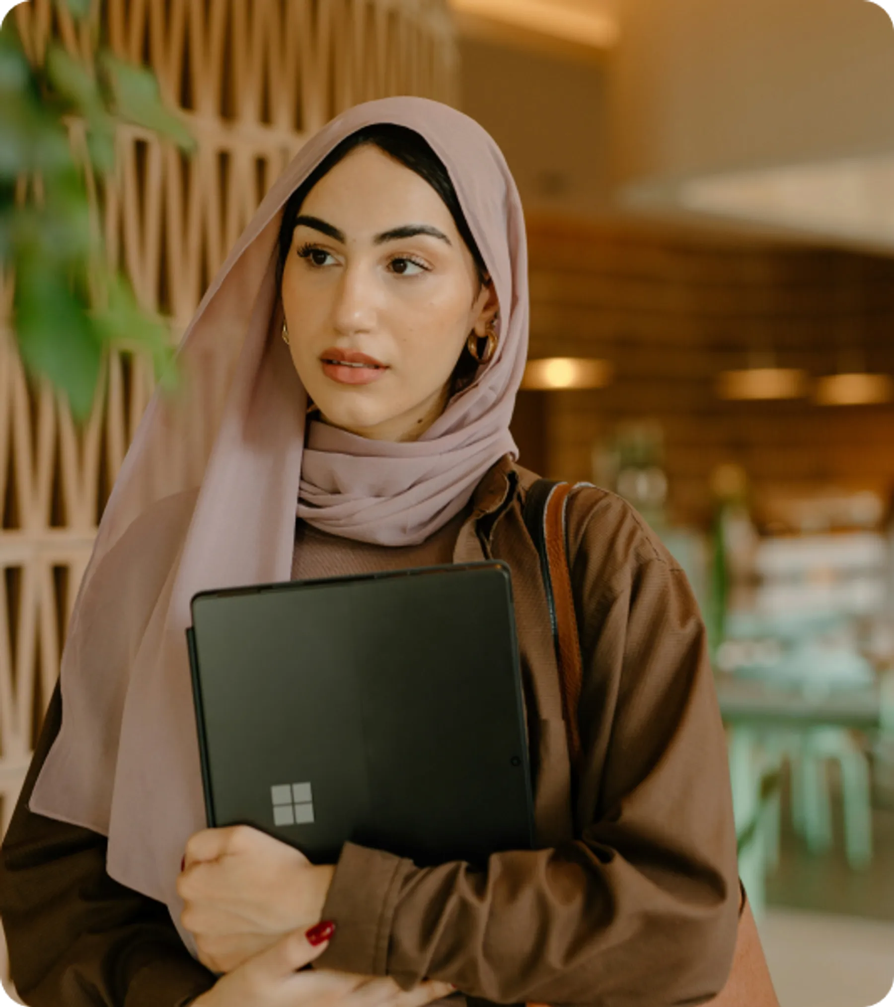 Professional woman in hijab holding a laptop, representing candidates for the UK Temporary Work – Government Authorised Exchange Visa