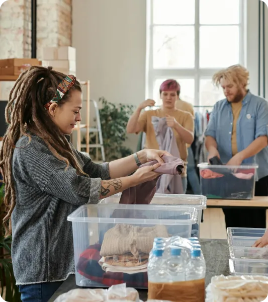 Group of people sorting clothes in a volunteer setting representing temporary worker visa applicants in the UK