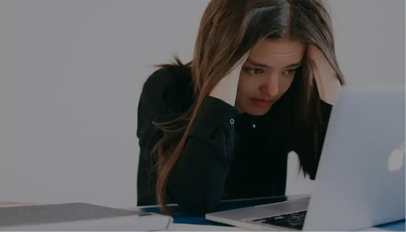 Concerned woman working at laptop, representing UK visa 60-day grace period stress or uncertainty