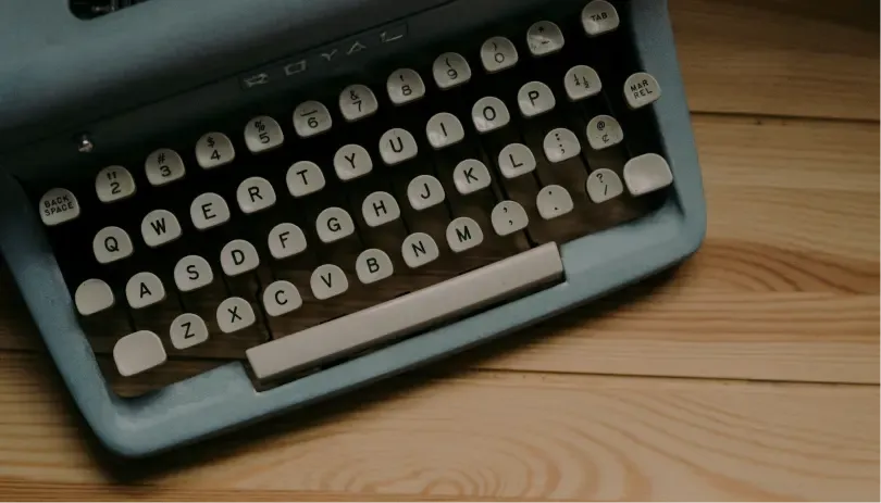 Close-up of a vintage typewriter on a wooden desk, symbolizing traditional correspondence or retro documentation