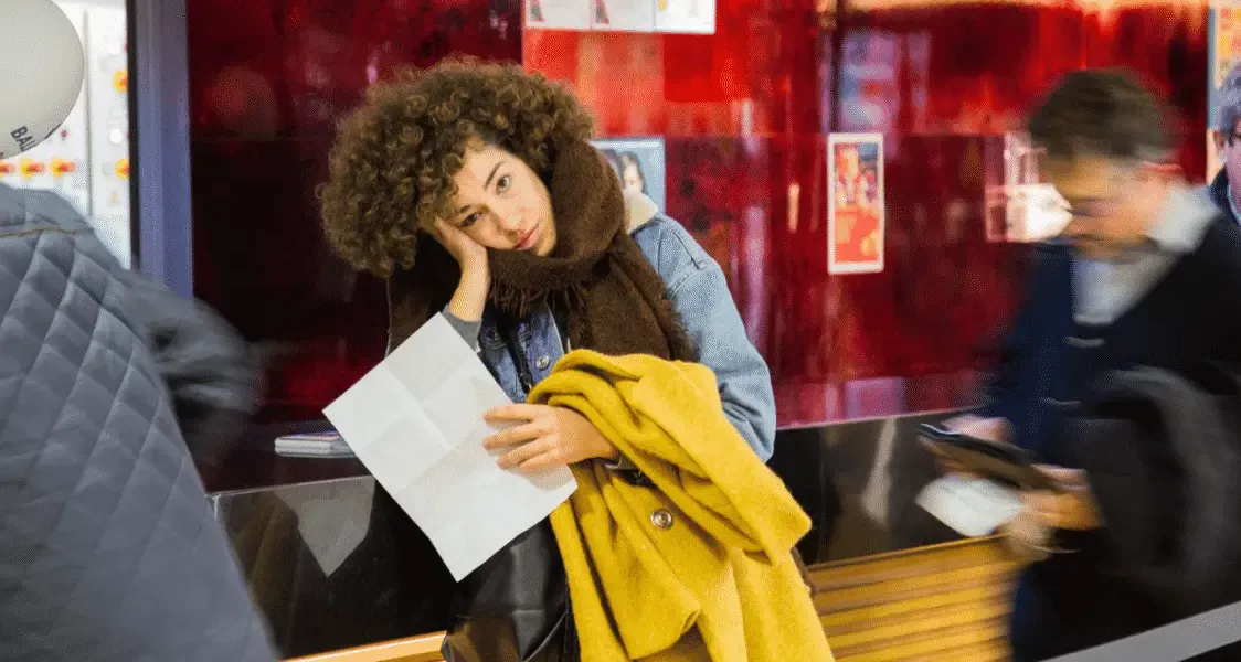 Woman holding passport and immigration documents at a train station, preparing for international travel
